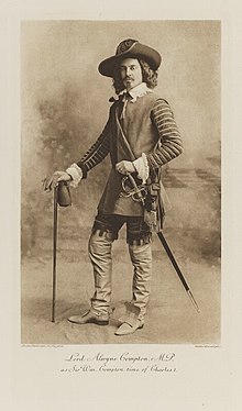 Black-and-white photograph of a standing man richly dressed in an historical costume