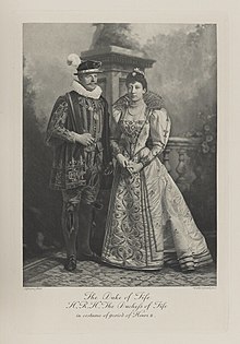 Black-and-white photograph of a man and woman richly dressed in historical costumes