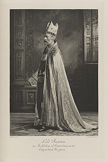 Black-and-white photograph of a standing man richly dressed as an Archbishop in an historical costume