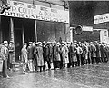 A group of unemployed Americans gather at a Soup Kitchen organized by Al Capone[15]