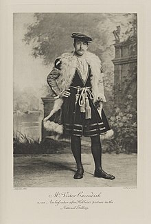 Black-and-white photograph of a standing man richly dressed in an historical costume and wearing the insignia of the Golden Fleece