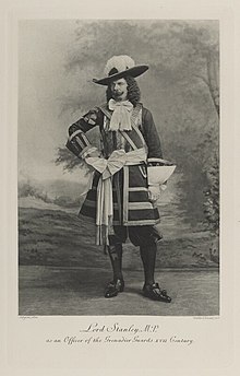 Black-and-white photograph of a standing man richly dressed in an historical costume