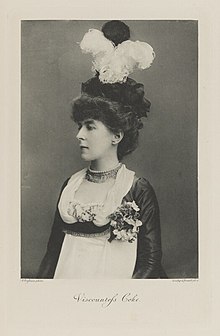 Black-and-white photograph of the head and torso of a woman with black and white plumes in her hair