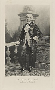 Black-and-white photograph of a standing man richly dressed in an historical costume