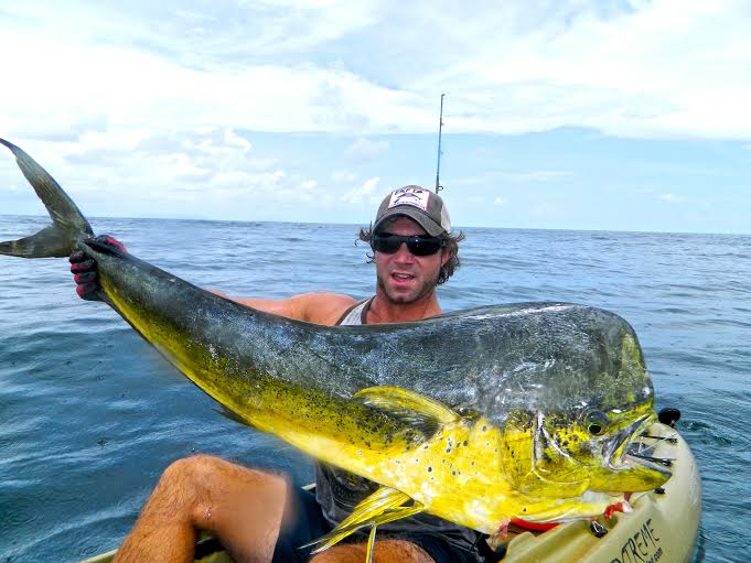 Kayak angler holds up a huge Mahi fish he just caught off the shores of Pompano Beach, FL