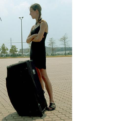 File:Standing woman with suitcase black dress.JPG