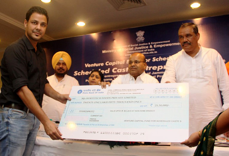 Thaawar Chand Gehlot presenting the cheque to the beneficiaries of Venture Capital Fund for Scheduled Castes, during the Scheduled Caste Entrepreneurs Meet