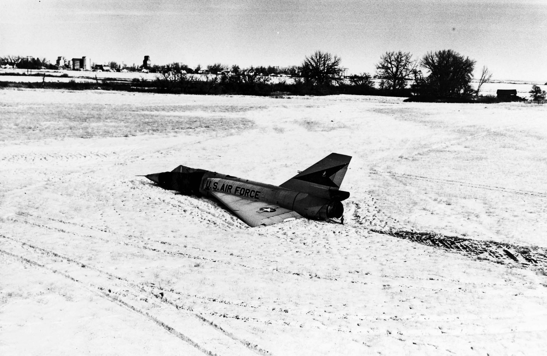 An old airplane sitting on top of a field covered in snow photo