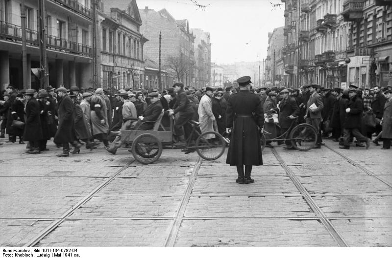 Polen, Warschau.- Straßenszene, Passanten und Rikshas beim Überqueren einer Straße, "Ghettopolizist" beim Regeln des Verkehrs, 1941