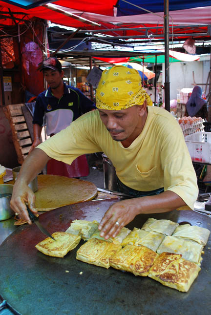 Murtabak being made at a stall, a type of pancake filled with eggs, small chunks of meat and onions.