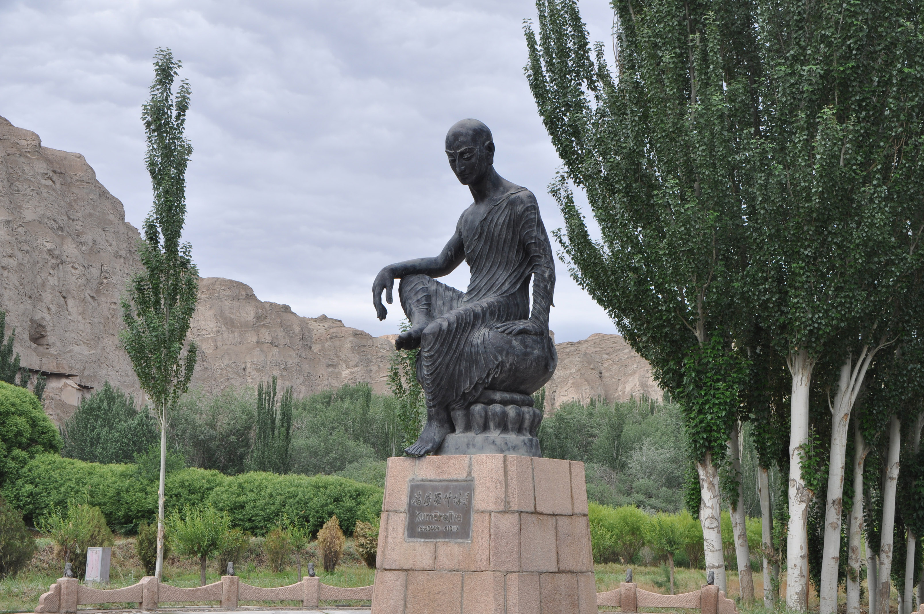 The Statue of Kumārajīva in front of the [[Kizil Caves]] in [[Kuqa County]], [[Xinjiang]], [[China]]