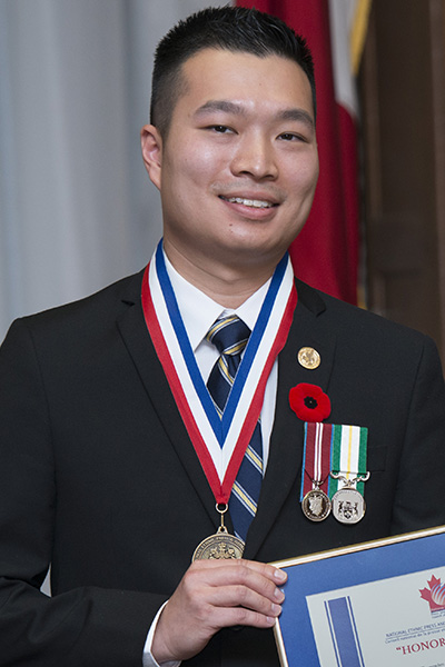 Paul Nguyen receiving an award at the Ontario Legislative Building.