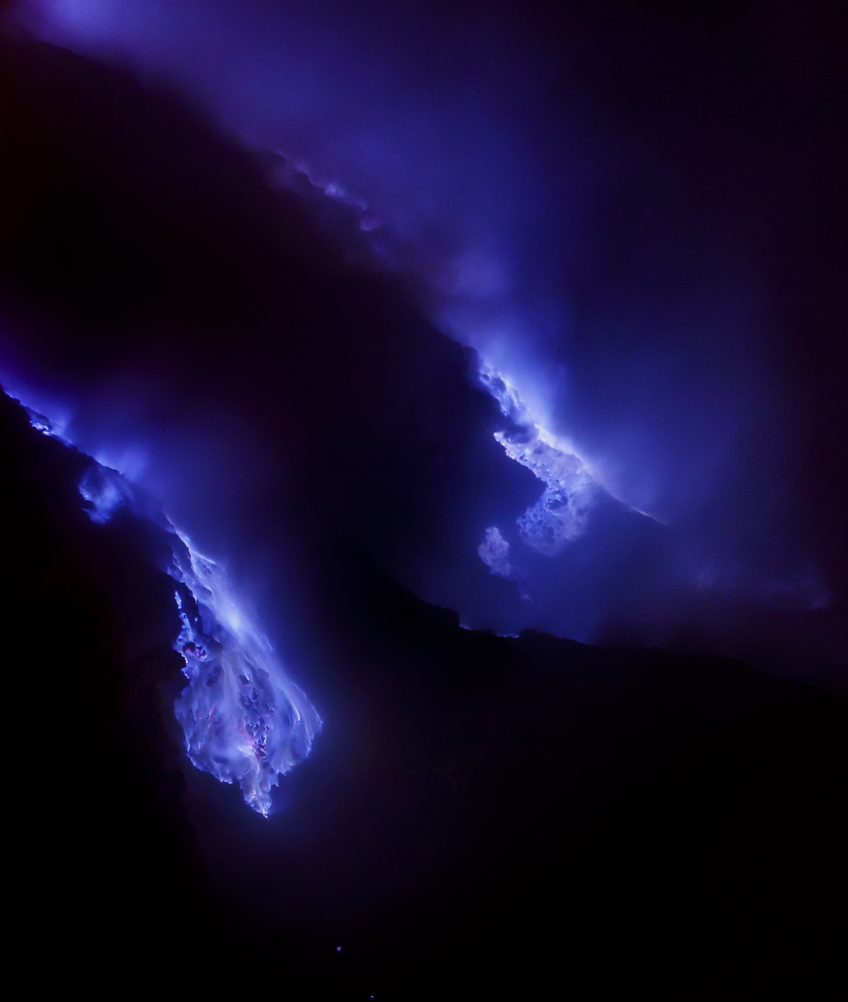 Fotografia notturna che mostre le fiamme azzurre dello zolfo nella caldera del vulcano Kawa Ijen