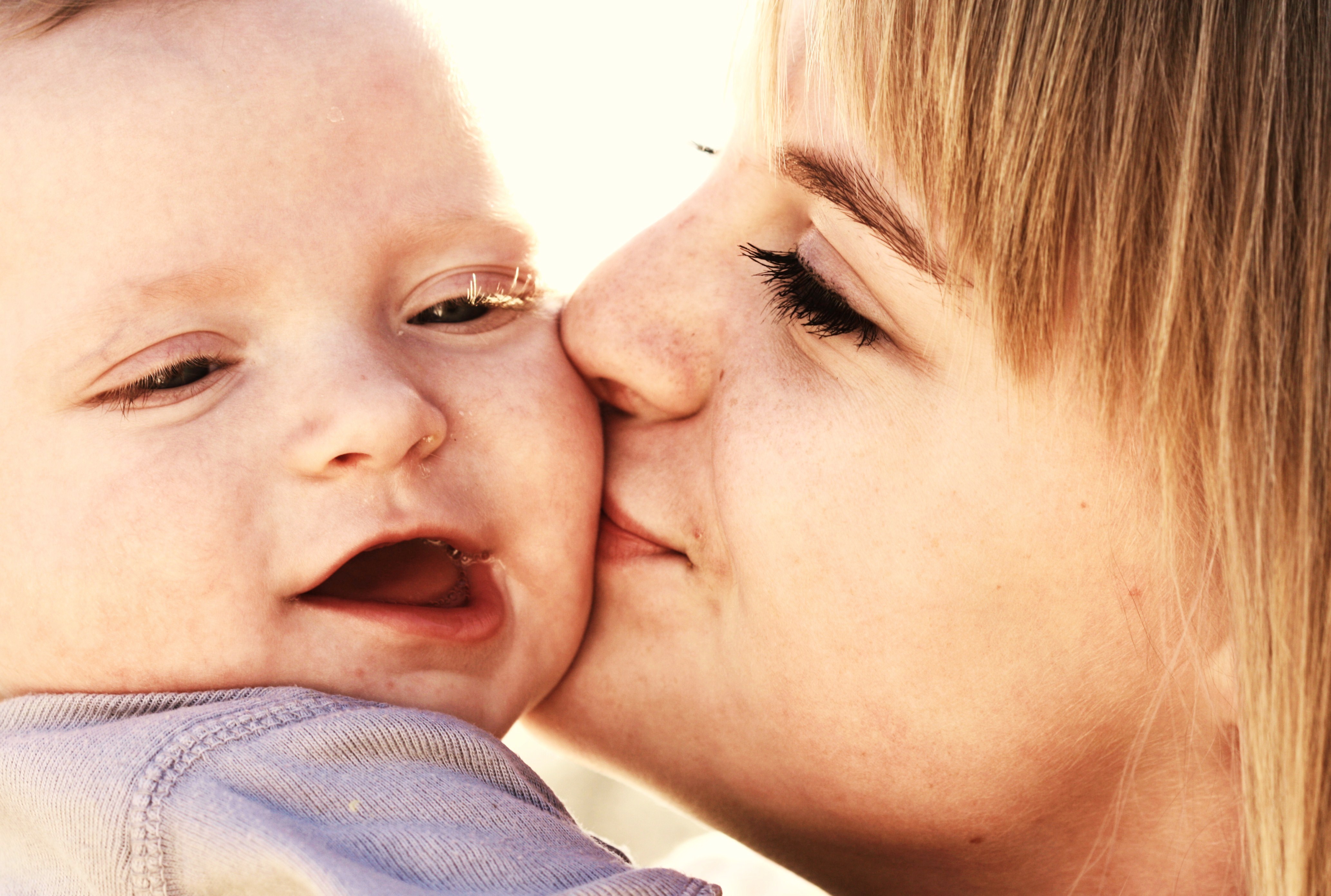 Woman kissing a baby on the cheek