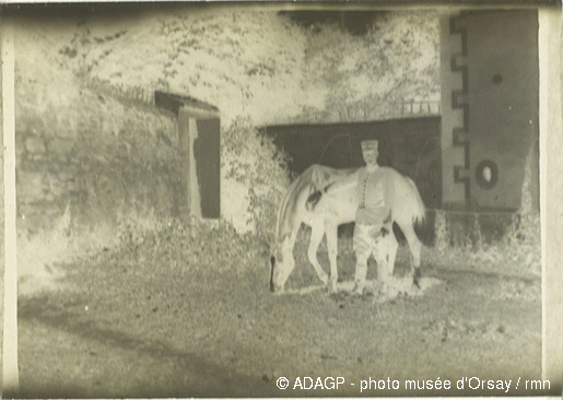 File:Militaire caressant le cheval qui broute l'herbe.gif