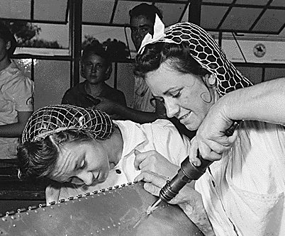 Two women working at a Texas Naval Air Base in 1942, wearing hairnets (snoods)