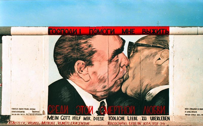Soviet premier Leonid Brezhnev locked in a mouth-to-mouth kiss with East German leader Erich Honecker above the legend My God, Help Me to Survive This Deadly Love