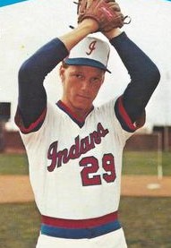 A man in a light baseball uniform and cap