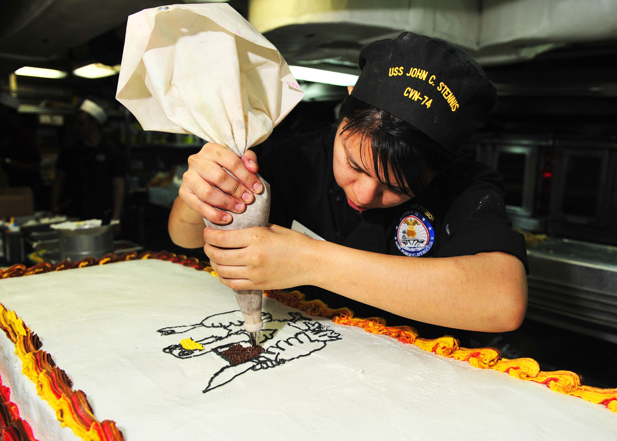 https://upload.wikimedia.org/wikipedia/commons/2/2a/US_Navy_111123-N-EZ913-060_Culinary_Specialist_Seaman_Lindsey_Ocampo%2C_from_Santa_Ana%2C_Calif.%2C_decorates_a_cake_in_preparation_for_Thanksgiving_din.jpg