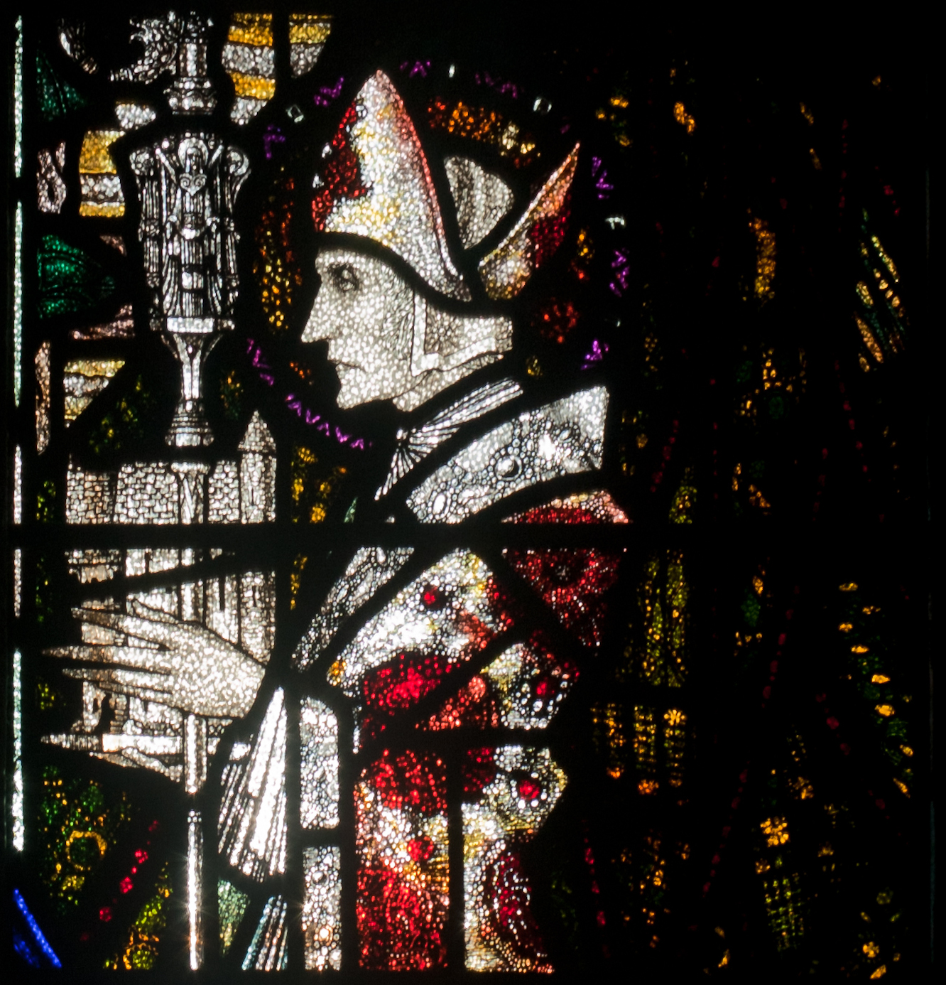 Detalj fra høyre del av glassmaleriet «Madonna med de hellige Aidan og Adrian» av Harry Clarke (1889–1931), som viser Aidan i profil. The Church of the Assumption i Wexford (wikimedia.org)