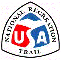 Rond driehoekig logo met "National Recreation Area" rond de rand en een rood, wit en blauw "USA" met de "S" gestileerd als een pad dat naar bergen leidt