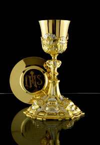Traditional gold chalice and paten inscribed with IHS.