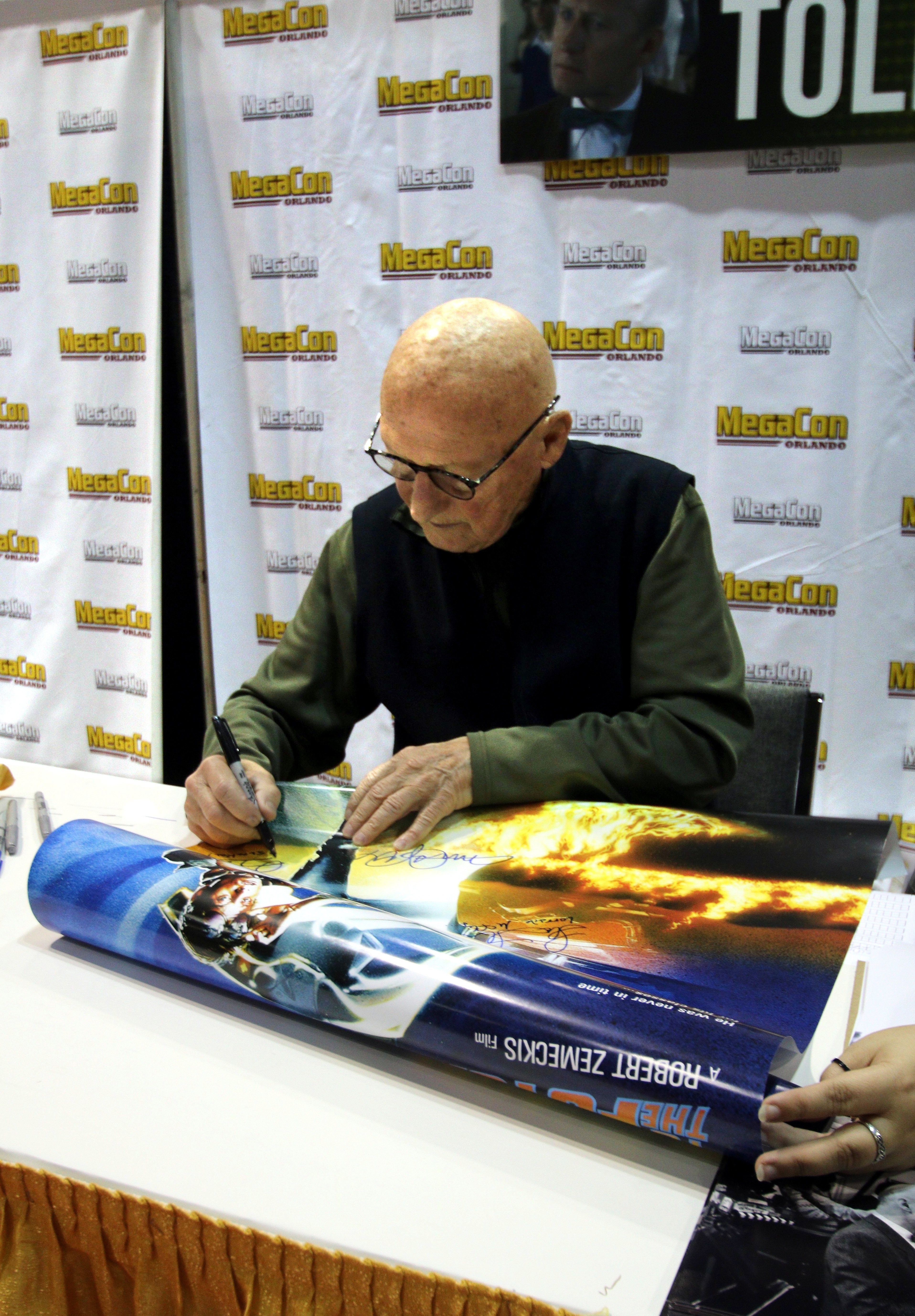 Tolkan autographing a ''[[Back to the Future]]'' poster in 2019