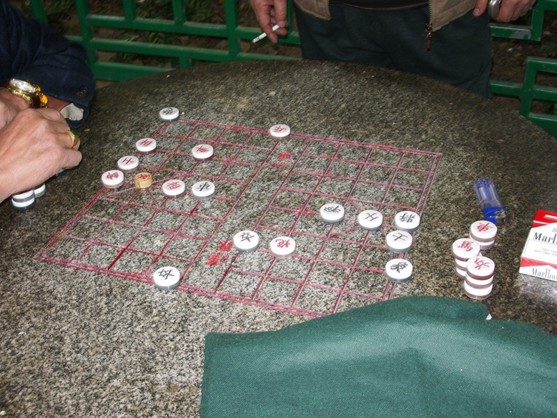 I am at a park on Temple Street in Yau Ma Tei, watching a game of xiangqi (Elephant Game), or Chinese chess, in progress