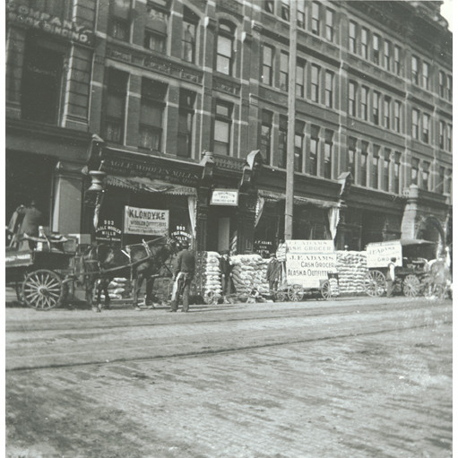 File:Dog sled team and mining supplies stacked on street in front of J F Adams, Alaska Outfitters store, Seattle, Washington, March (KIEHL 235).jpeg