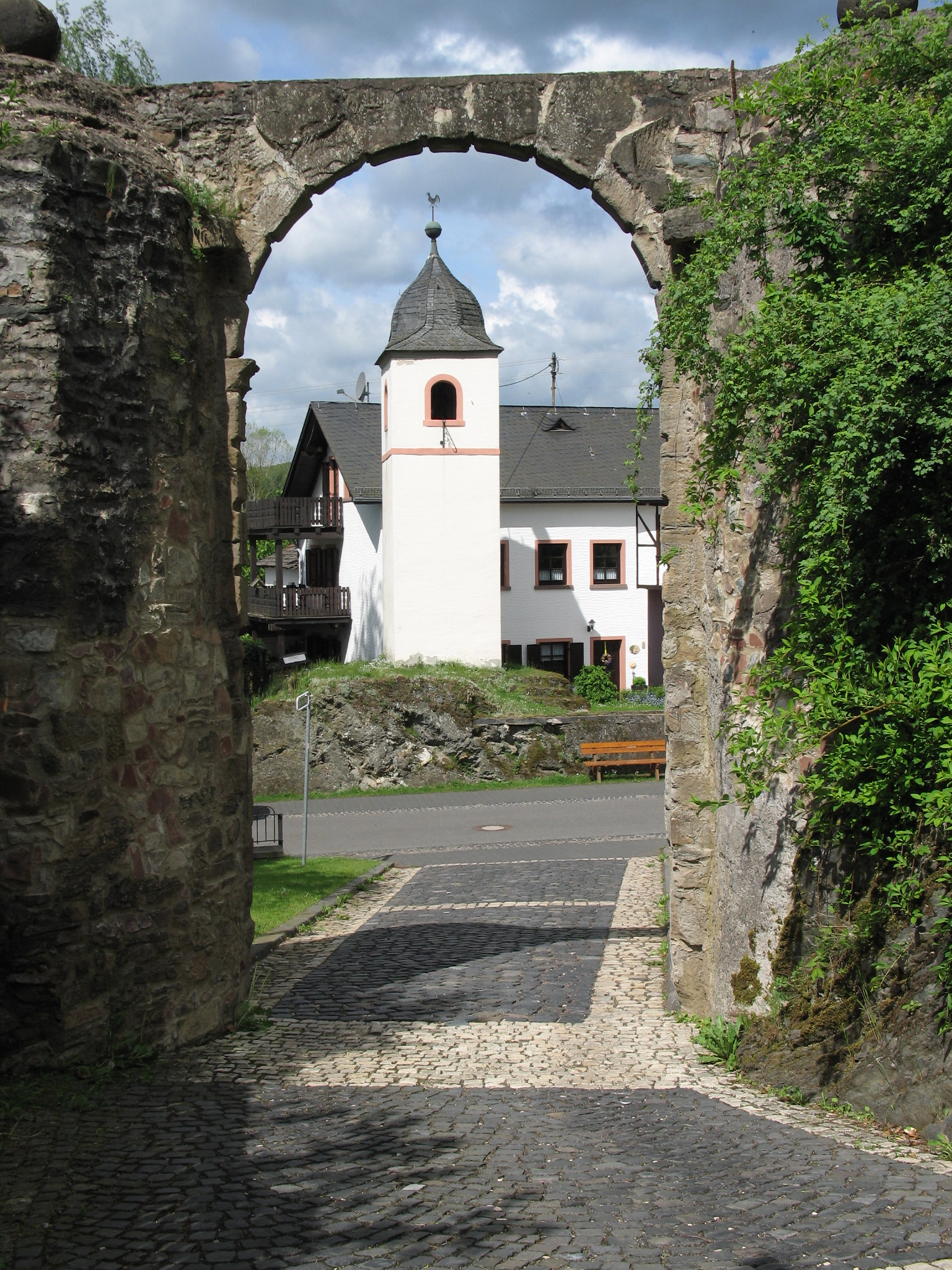 Blick aus dem Tor der Ruine der Burg Dhronecken auf den Glockenturm der Gemeinde. Fotografiert und z...