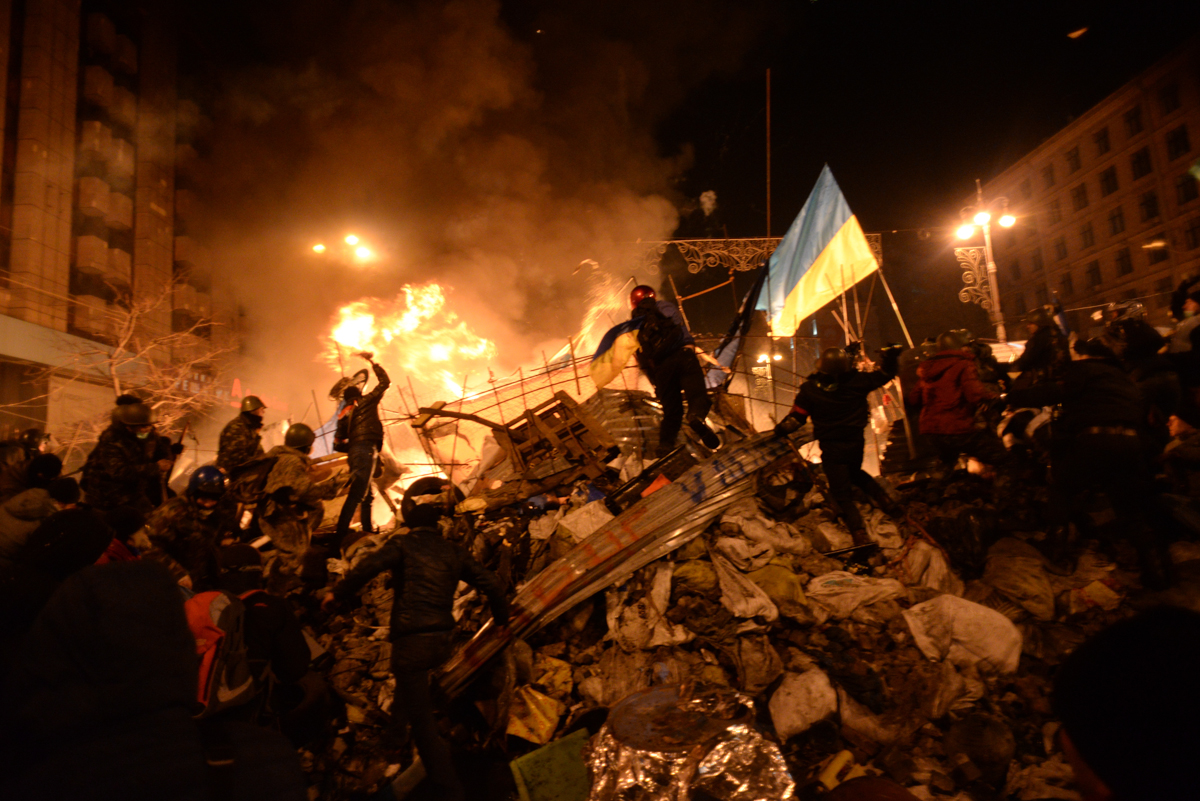 Bandeira do estado da Ucrânia carregada por um manifestante no centro dos confrontos em desenvolvimento em Kiev, na Ucrânia.  Eventos de 18 de fevereiro de 2014.jpg