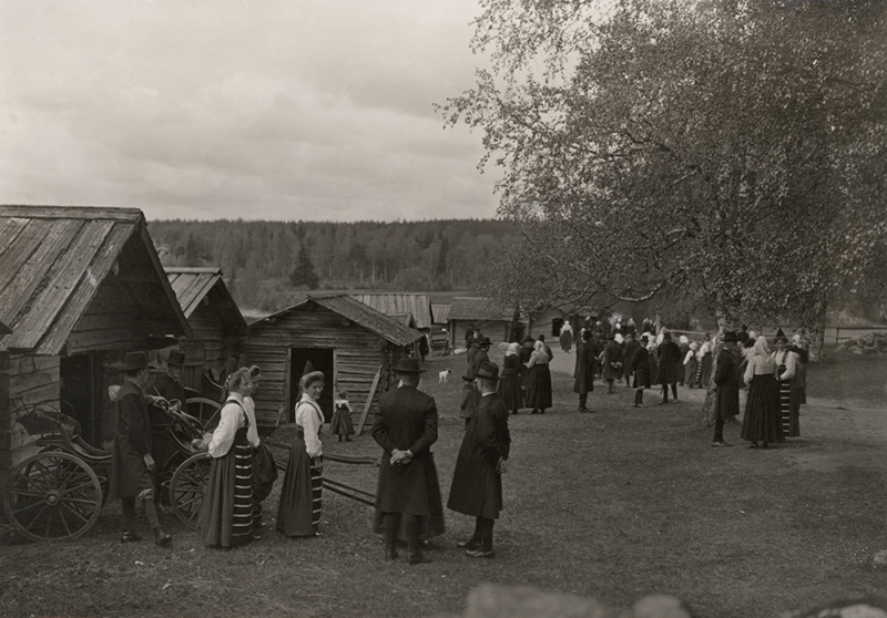 File:Högtidsklädda människor samlade utanför kyrkstallarna vid Rättviks kyrka i Dalarna - Nordiska Museet - NMA.0060672.jpg