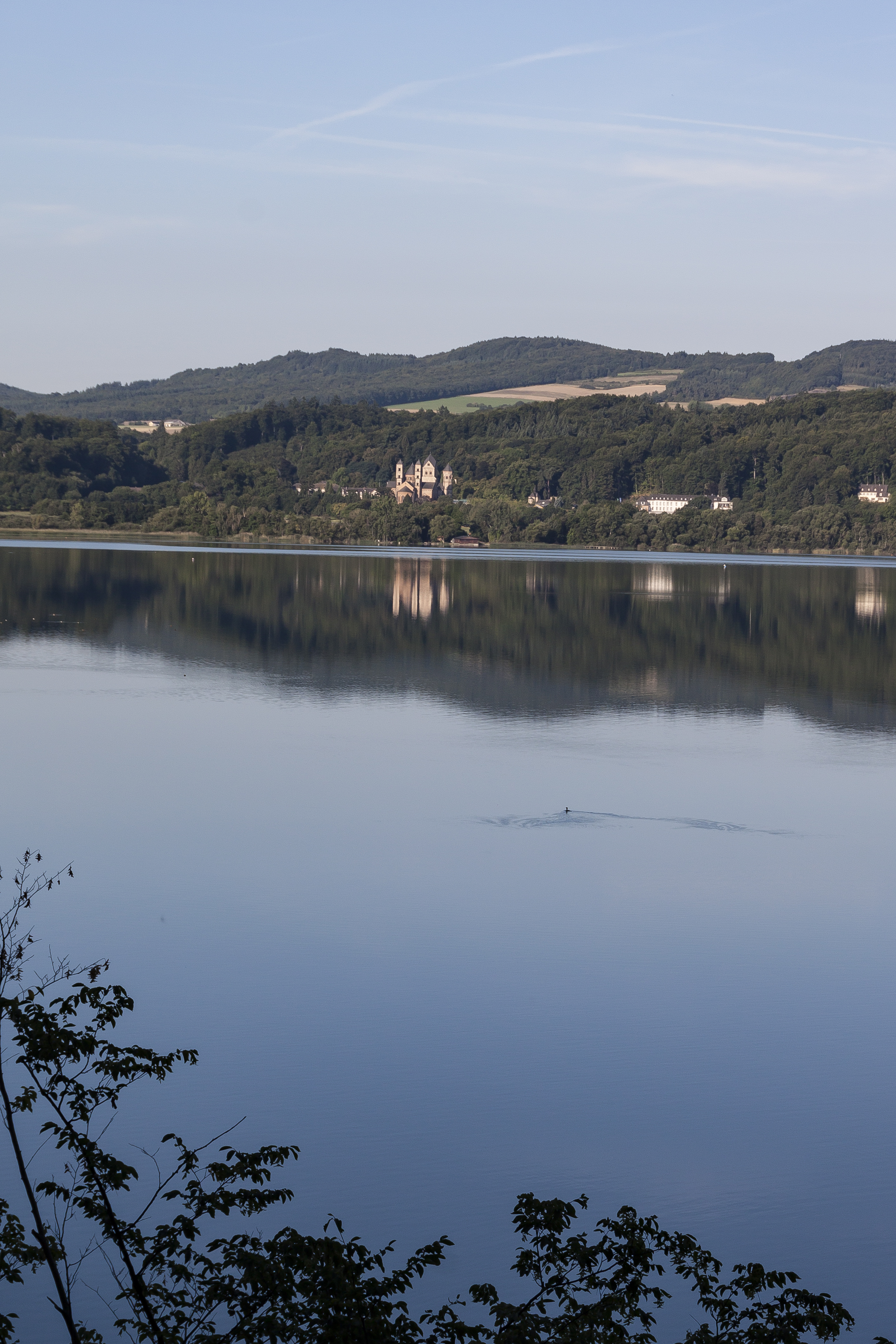 Naturschutzgebiet Laachersee. Die Abtei Maria Laach ist ein Kloster%2C das zu dem Benediktinerorden geh%C3%B6rt. Die hochmittelalterliche Klosteranlage ist an der S%C3%BCdwestseite des Laacher Sees gelegen%2C n%C3%B6rdlich von Mendig in der Eif