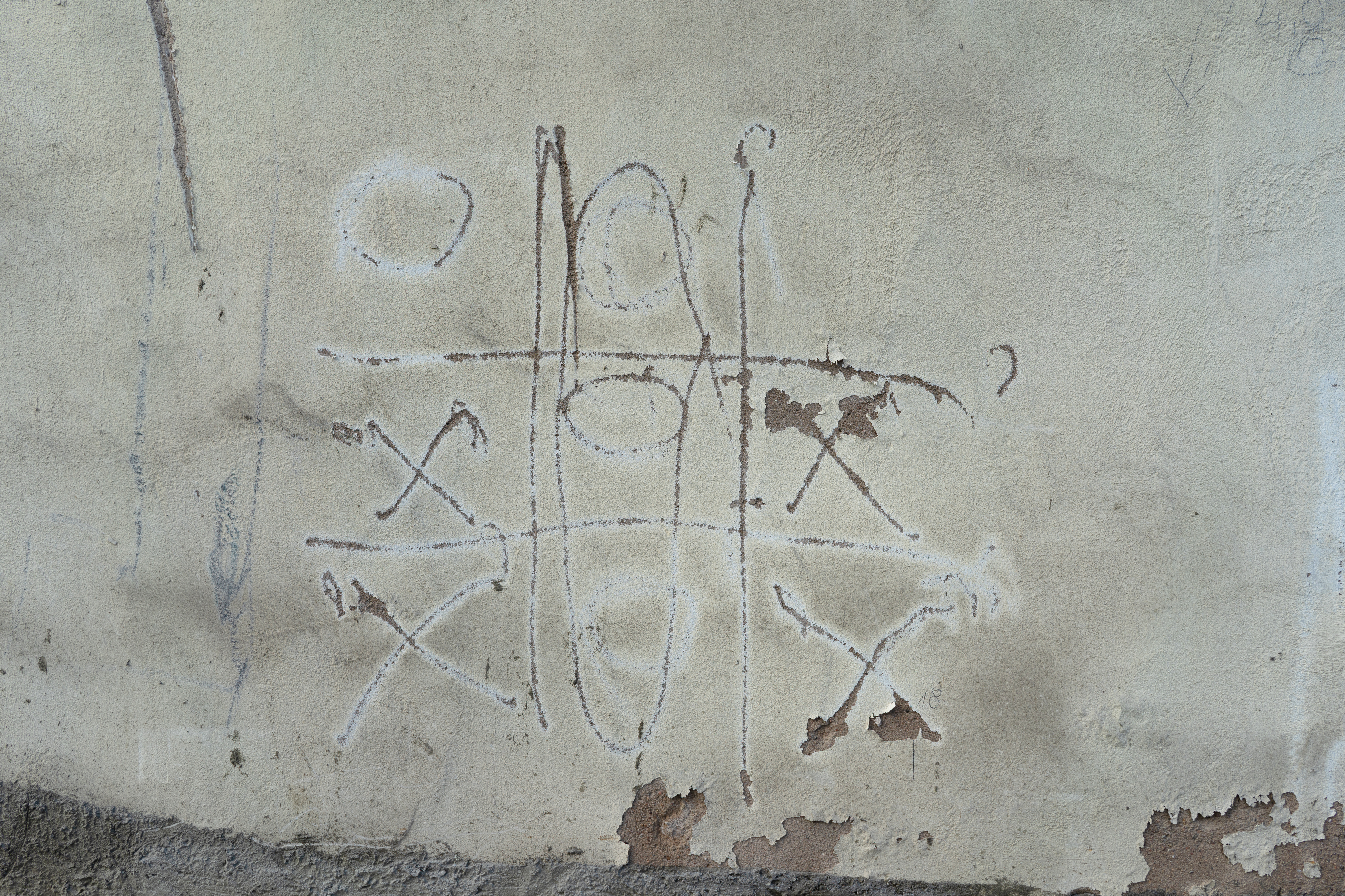 An image of a game of tic tac toe painted on a wall.