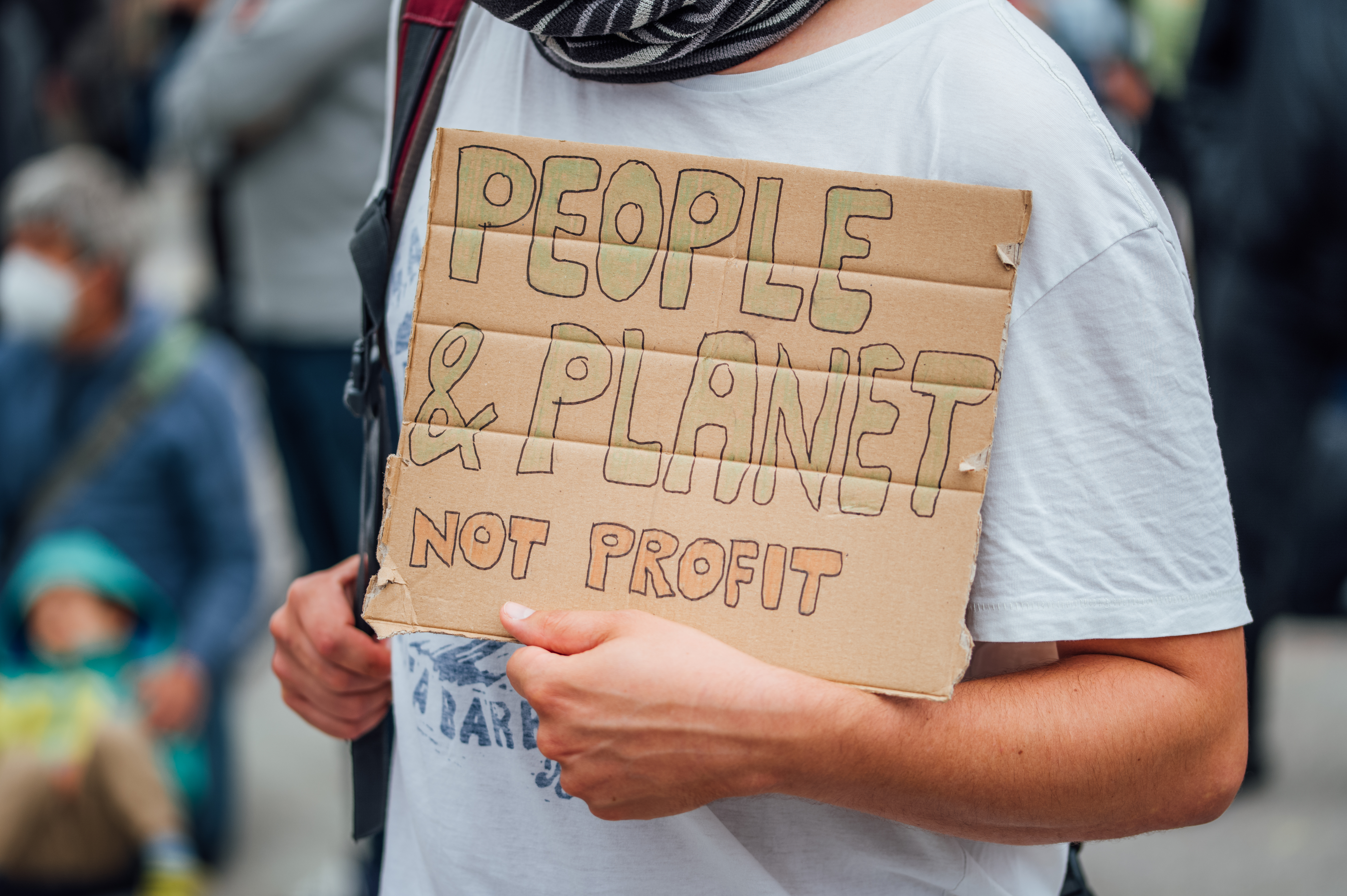 The message people. People Planet profit. Not profit. Holds protest sign Doodles. Message in people.