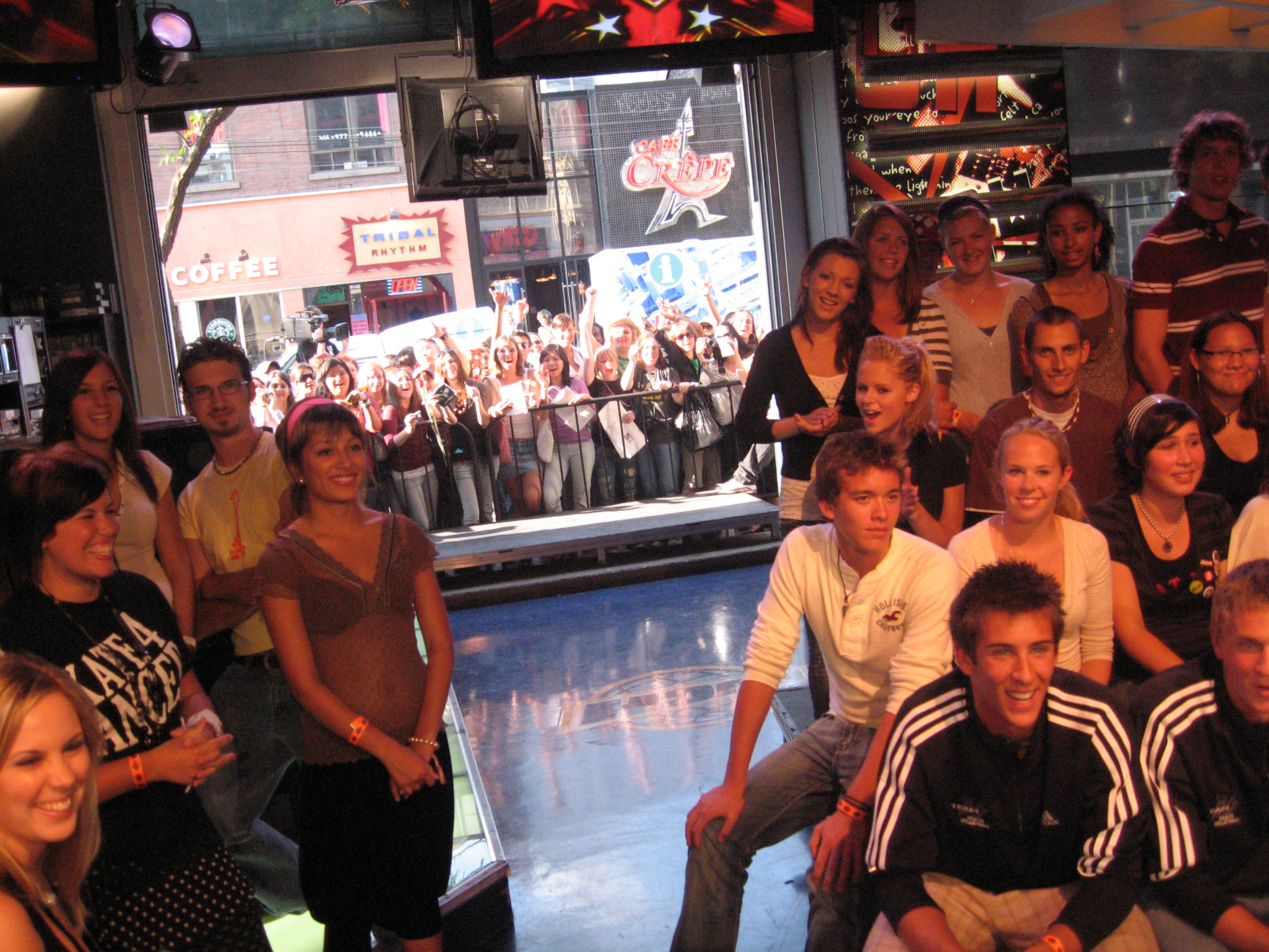 An image of a smiling indoor-outdoor crowd gathered for a live MuchMusic performance