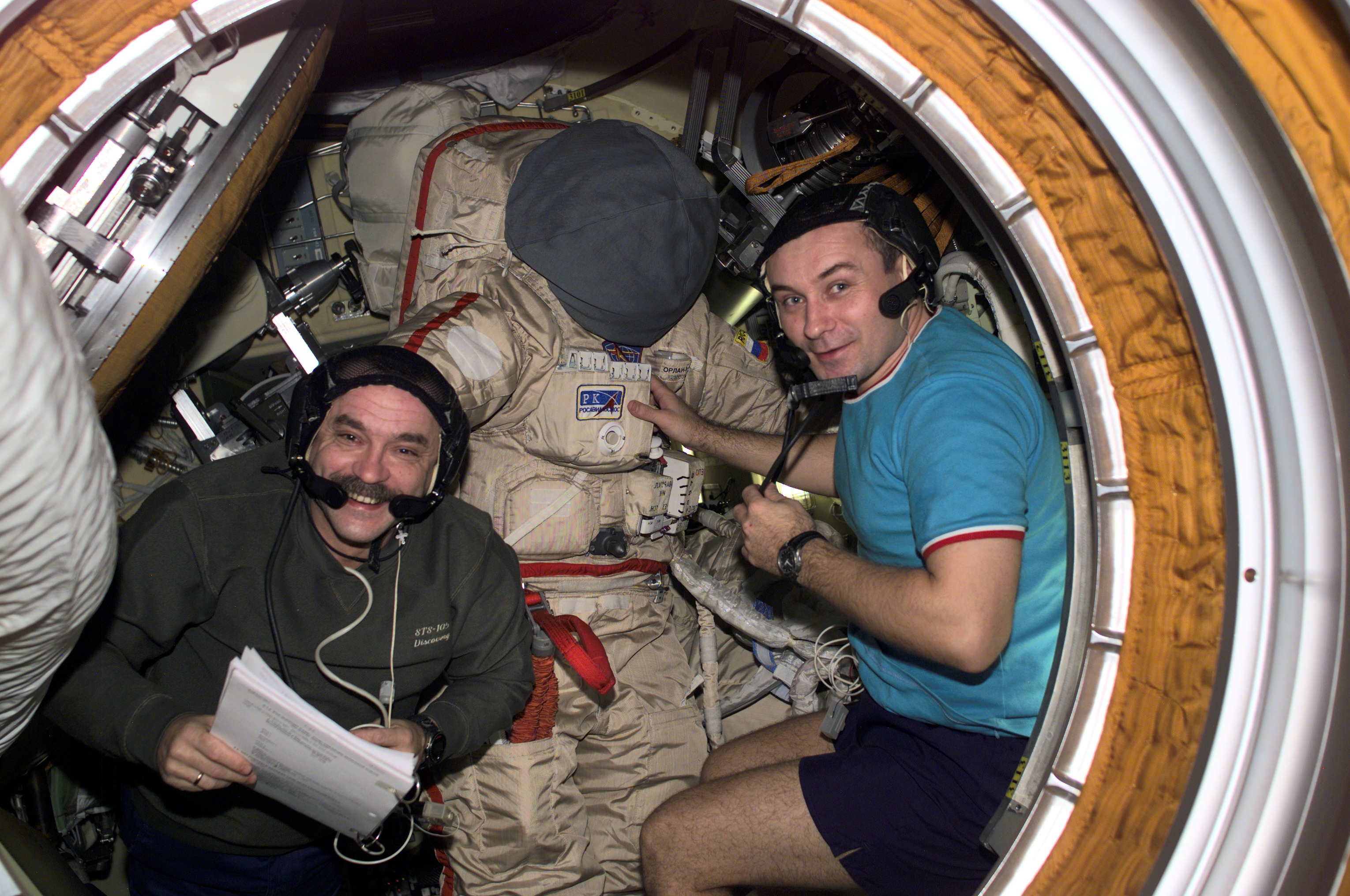 Космонавты Владимир Дежуров и Михаил Тюрин (слева) готовят российский скафандр «Орлан»