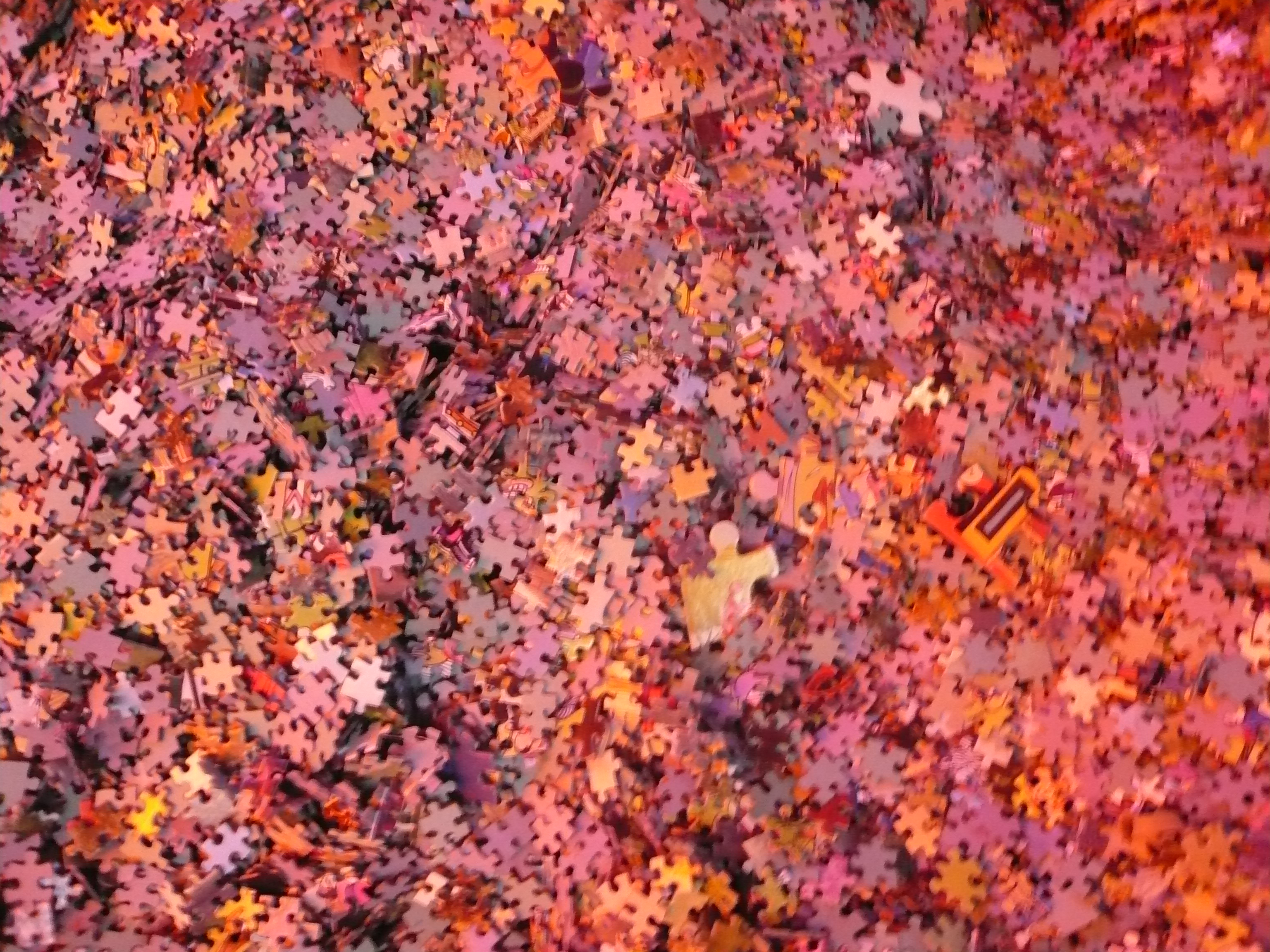 Huge jumble of red, pink, and orange puzzle pieces