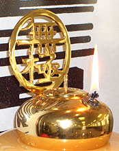An oil lamp is an element at the center of a Yiguandao shrine, below the effigy of Maitreya.