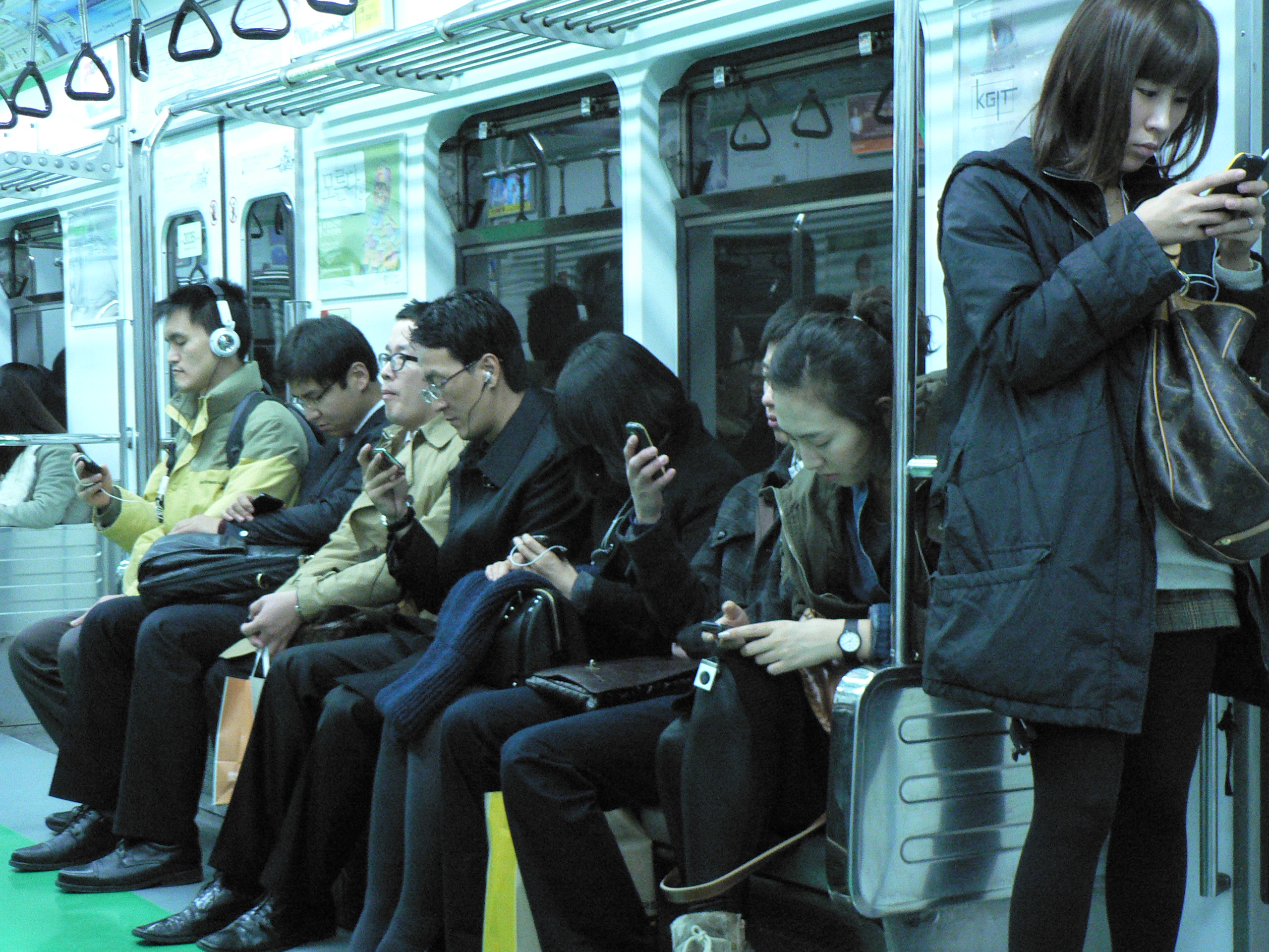 Телефоны в южной корее. Метро в Южной Корее. Люди уткнулись в смартфоны. Человек с телефоном. Люди с гаджетами в метро.