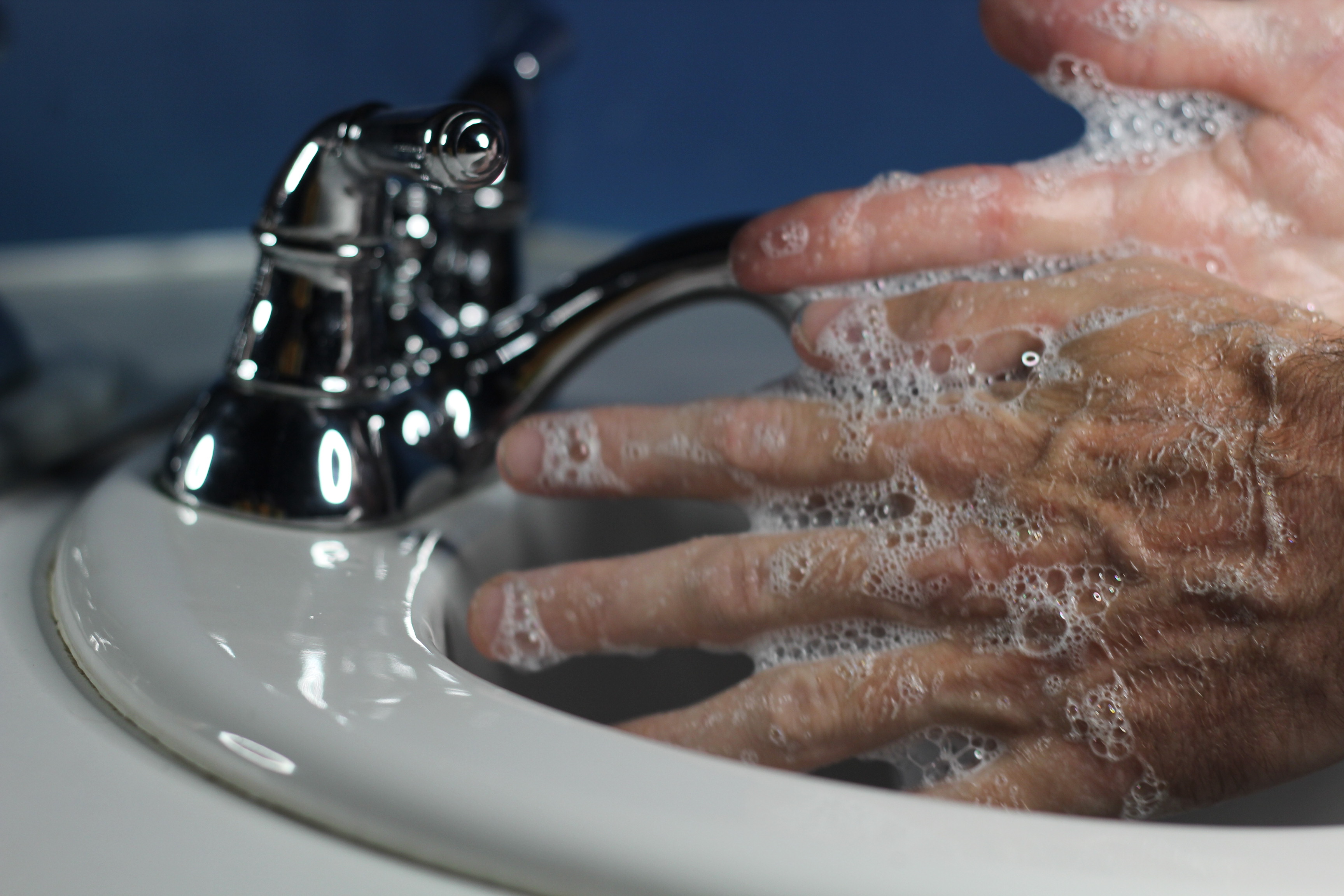 Мужчина моет руки счастливые. Man washing hands back.