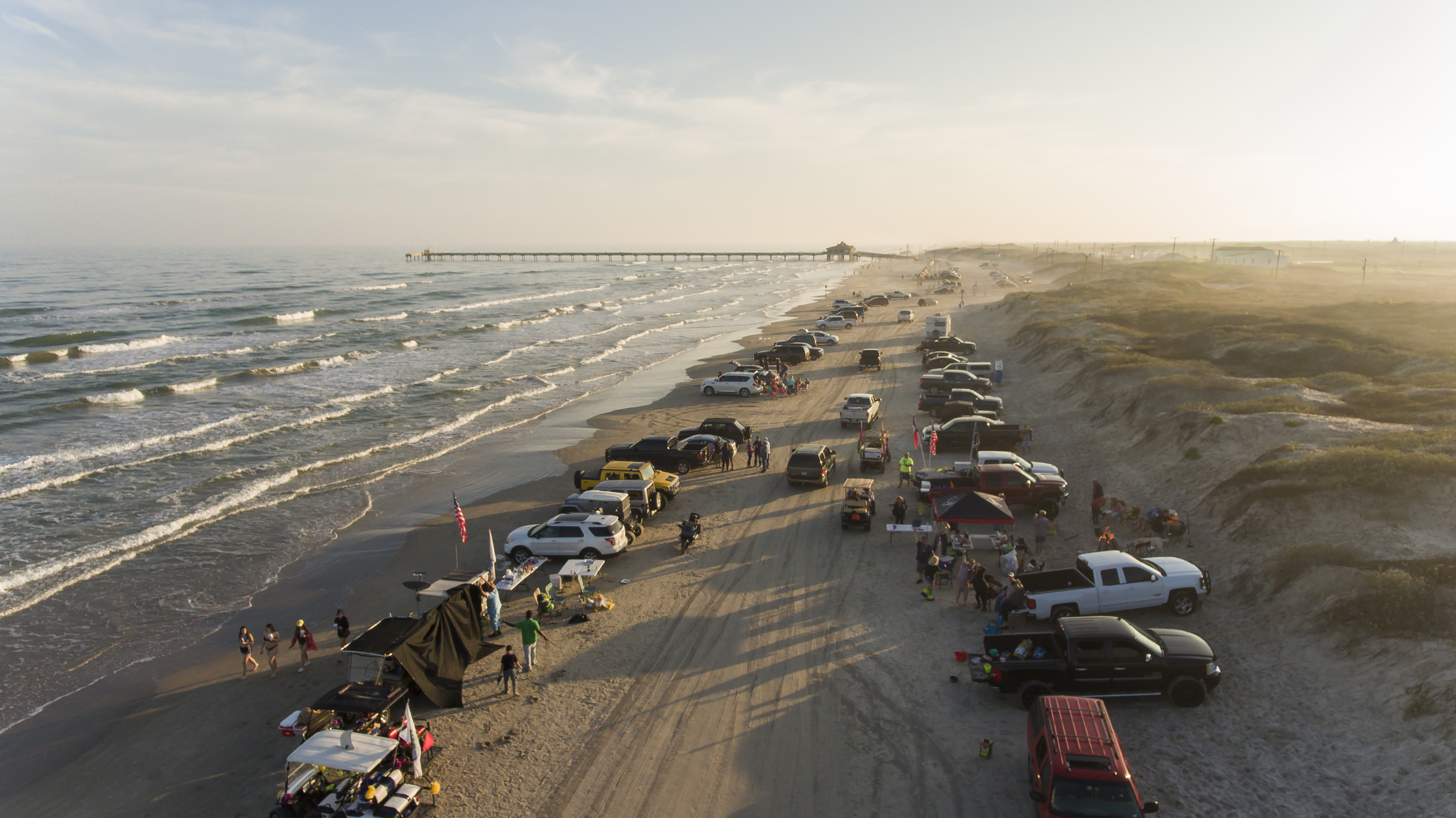 An aerial view of South Padre Island with people parked and driving on the beach...