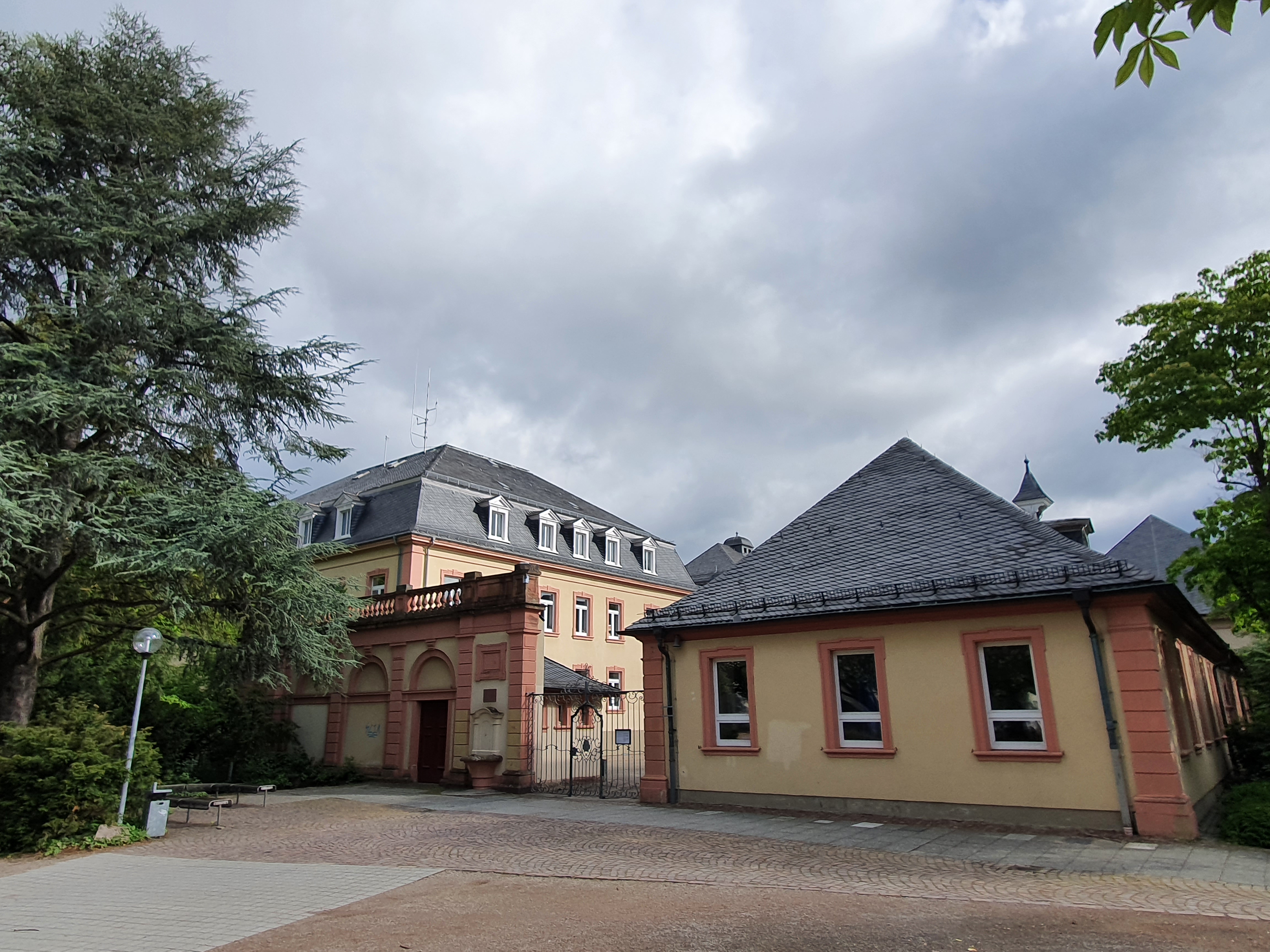 Blick vom Vorplatz auf den Eingang des Schönborn-Gymnasiums Bruchsal, mit Altbau im Hintergrund.