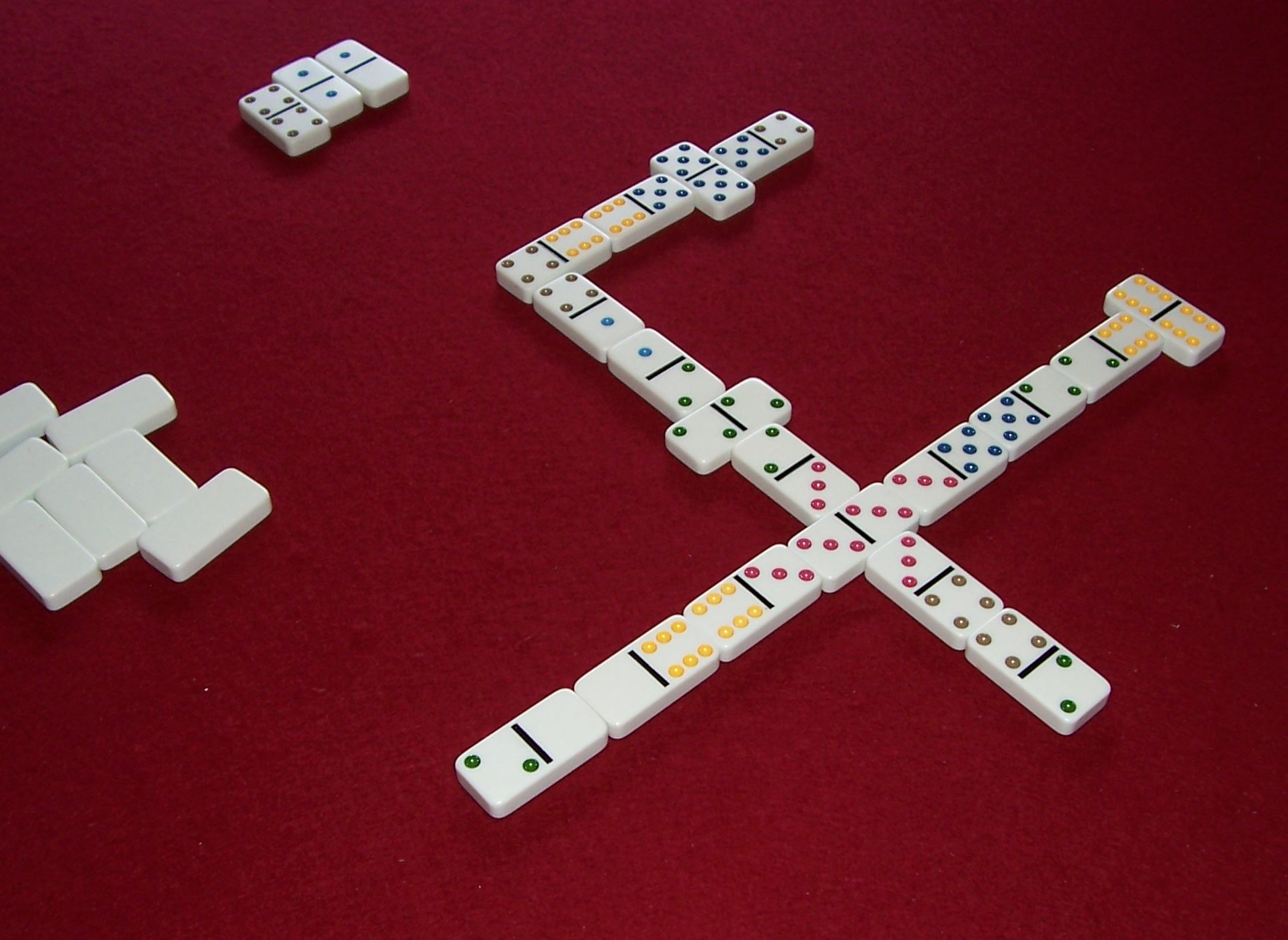 Muggins played with multicolored tiles: The doubles serve as spinners, allowing the line of play to branch.