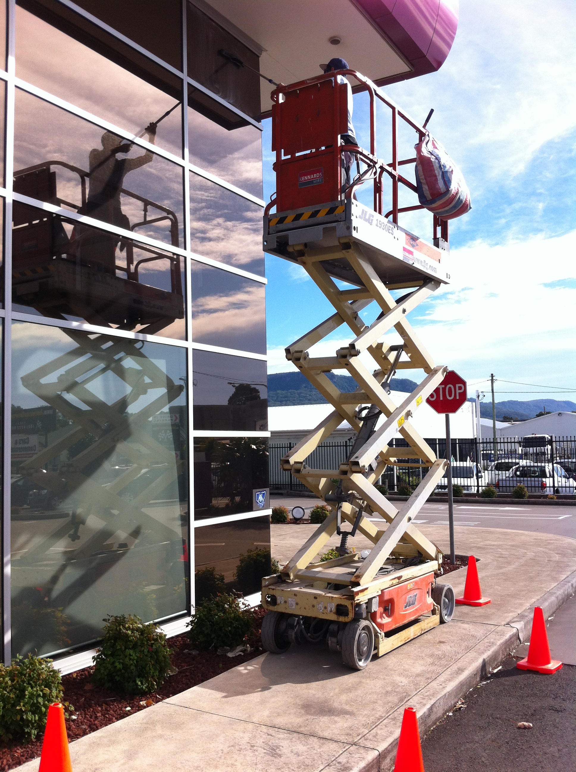 A scissor lift aerial work platform is being used to access high windows