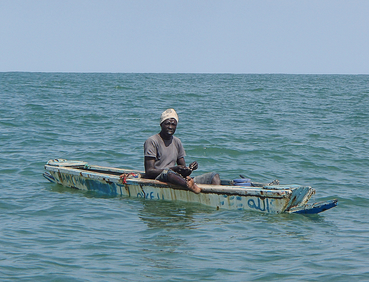 File:Fisherman with a line on a small boat Gambia.jpg - Wikimedia Commons