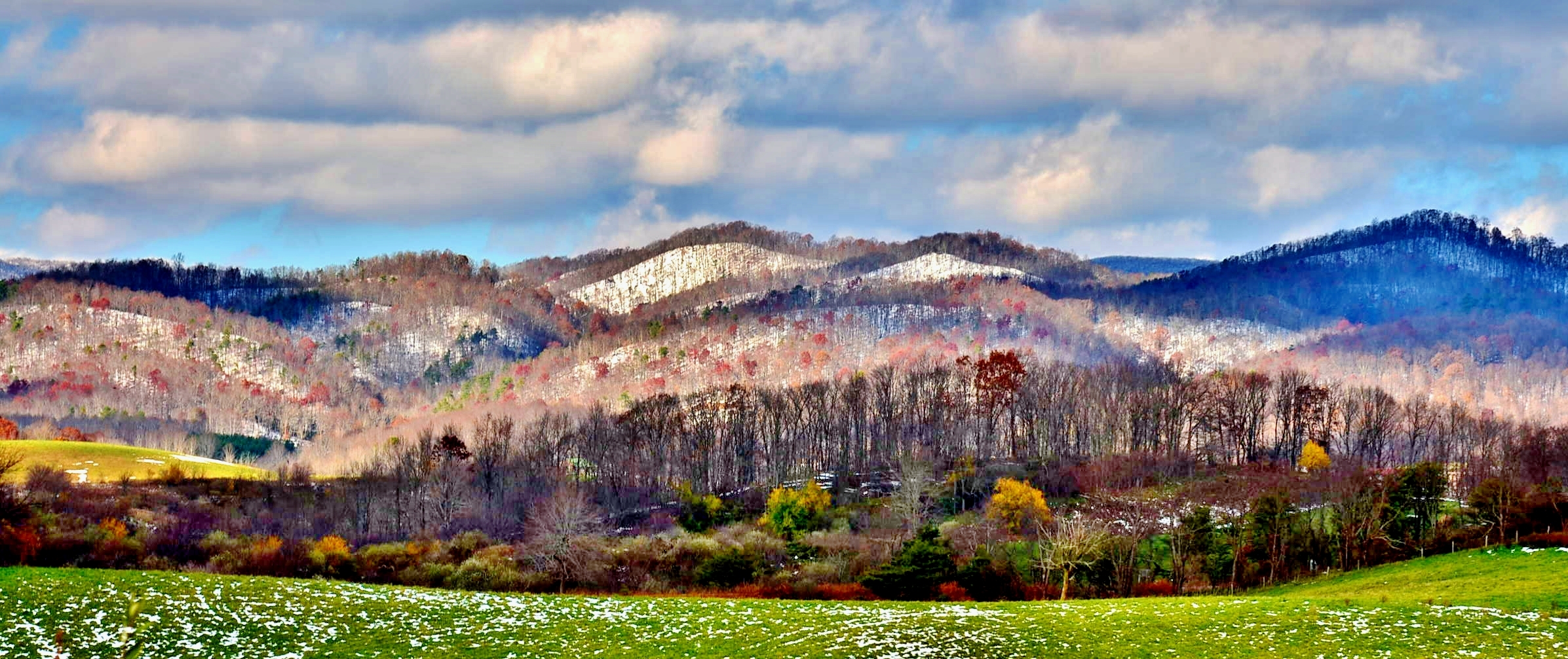 mountains with green grass in the foreground