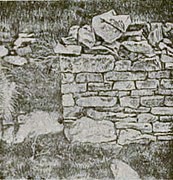 Fotografia em preto e branco das ruínas de uma parede de igreja
