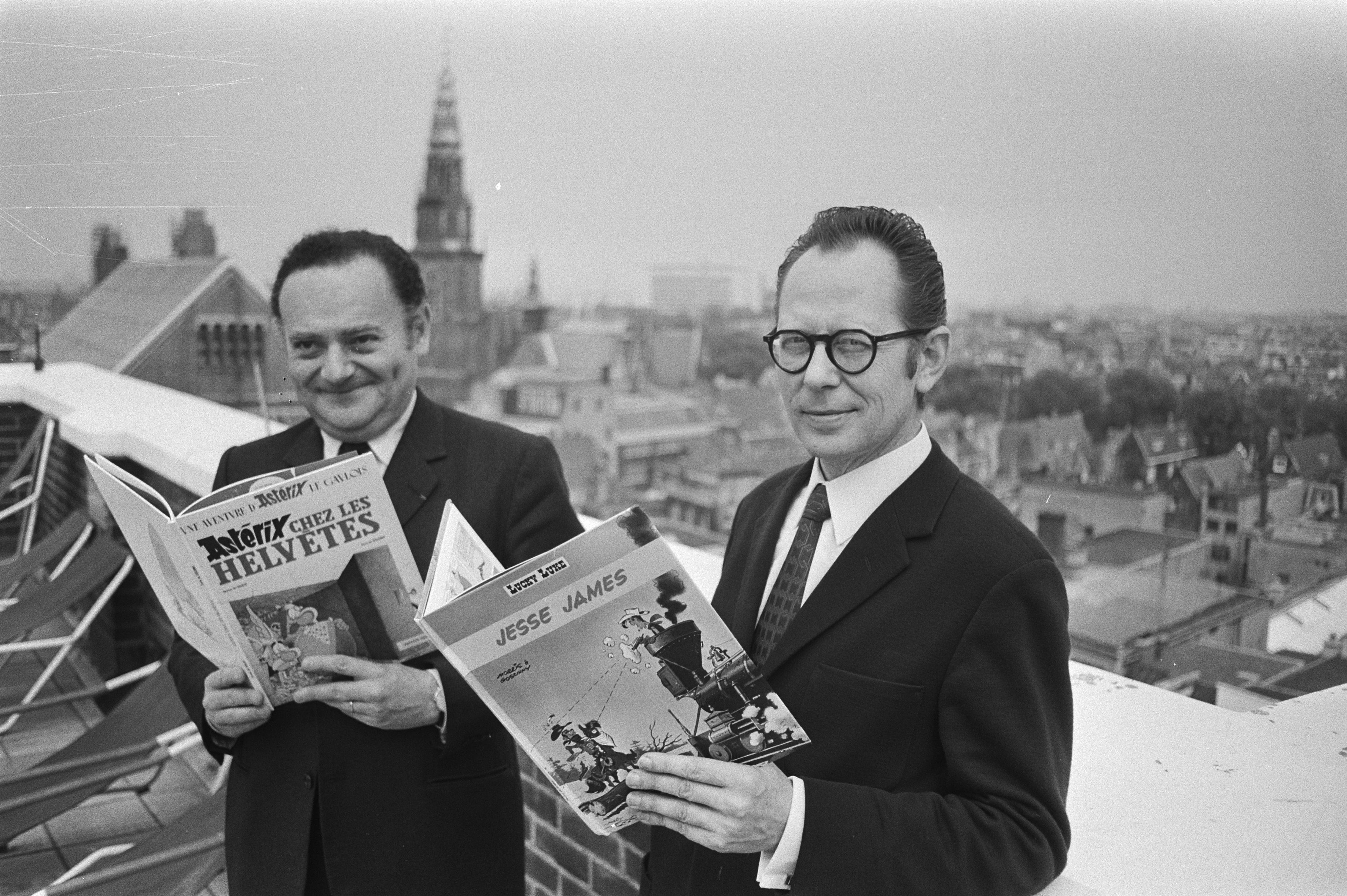 BD Authors René Goscinny (L) and Morris (R) in 1971, holding Asterix and Lucky Luke albums respectively (Source: Wikimedia Commons)
