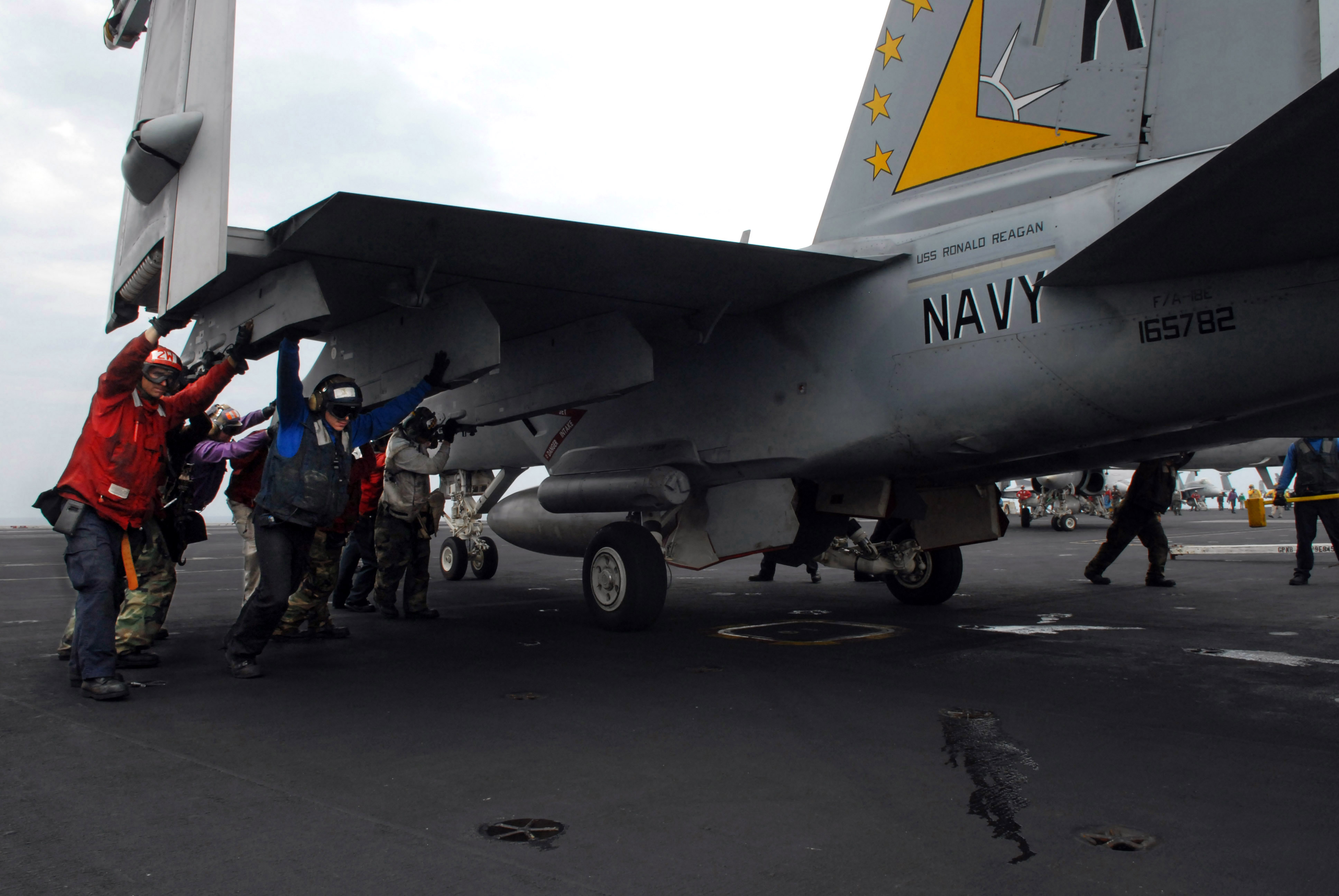 File Us Navy N 3659b 155 Members Of Carrier Air Wing Cvw 14 And Other Flight Deck Personnel Participate In A Manual Push Back Of An F A 18e Super Hornet Assigned To The Eagles Of Strike